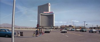 Movie still from “Diamonds Are Forever” (1971), directed by Guy Hamilton – A street scene with cars parked on the side of the road; Extreme Wide shot, Low angle