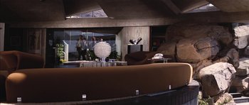 Movie still from “Diamonds Are Forever” (1971), directed by Guy Hamilton – A living room with a couch , chair , and a television set; Wide shot, Low angle