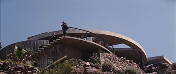 Movie still from “Diamonds Are Forever” (1971), directed by Guy Hamilton – A group of people standing on a concrete structure; Extreme Wide shot, Low angle