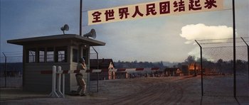 Movie still from “Diamonds Are Forever” (1971), directed by Guy Hamilton – A man standing in front of a building with a sign; Extreme Wide shot, Low angle