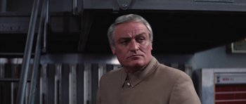 Movie still from “Diamonds Are Forever” (1971), directed by Guy Hamilton – An older man in a brown jacket looking at the camera; Close Up shot, Low angle
