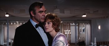 Movie still from “Diamonds Are Forever” (1971), directed by Guy Hamilton – A man and a woman standing next to each other in a room; Close Up shot, Low angle