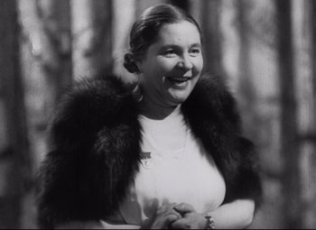 Movie still from “Diary for My Children” (1984), directed by Márta Mészáros – An old photo of a woman smiling for the camera; Close Up shot, Low angle