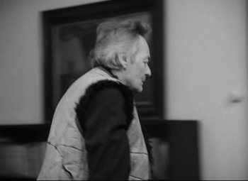 Movie still from “Diary for My Children” (1984), directed by Márta Mészáros – An older man walking in front of a painting; Medium shot, Over the shoulder angle