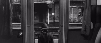 Movie still from “Diary of a Chambermaid” (1964), directed by Luis Buñuel – A person standing in front of a train; Wide shot, High angle