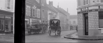 Movie still from “Diary of a Chambermaid” (1964), directed by Luis Buñuel – A horse drawn carriage on a street in a city; Extreme Wide shot, Low angle