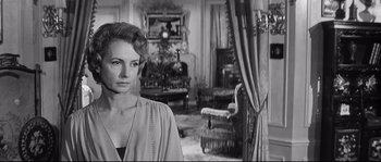 Movie still from “Diary of a Chambermaid” (1964), directed by Luis Buñuel – A black and white photo of a woman in a living room; Close Up shot, Over the shoulder angle