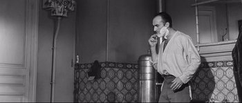 Movie still from “Diary of a Chambermaid” (1964), directed by Luis Buñuel – A black and white photo of a man brushing his teeth; Medium shot, Over the shoulder angle