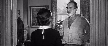 Movie still from “Diary of a Chambermaid” (1964), directed by Luis Buñuel – An old photo of a man and a woman; Medium shot, Over the shoulder angle