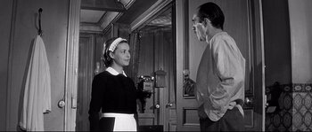 Movie still from “Diary of a Chambermaid” (1964), directed by Luis Buñuel – An old photo of a man and a woman talking; Medium shot, Low angle