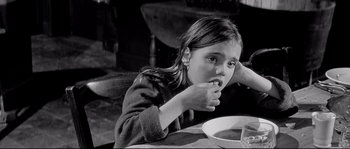 Movie still from “Diary of a Chambermaid” (1964), directed by Luis Buñuel – A young girl sitting at a table eating a bowl of soup; Close Up shot, High angle