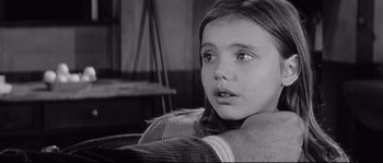 Movie still from “Diary of a Chambermaid” (1964), directed by Luis Buñuel – A young girl sitting in a chair looking into the distance; Close Up shot, Over the shoulder angle