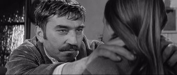 Movie still from “Diary of a Chambermaid” (1964), directed by Luis Buñuel – A black and white photo of a man and a woman; Close Up shot, Over the shoulder angle