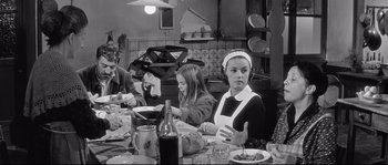 Movie still from “Diary of a Chambermaid” (1964), directed by Luis Buñuel – A group of people sitting at a table with food; Medium shot, High angle