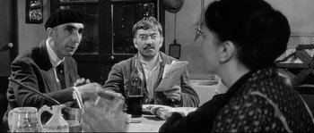 Movie still from “Diary of a Chambermaid” (1964), directed by Luis Buñuel – A black and white photo of a man and a woman at a table; Medium shot, Over the shoulder angle