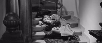 Movie still from “Diary of a Chambermaid” (1964), directed by Luis Buñuel – A woman laying on the ground on the steps; Medium shot, High angle