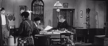 Movie still from “Diary of a Chambermaid” (1964), directed by Luis Buñuel – A man and a woman sitting at a dining room table; Wide shot, High angle