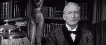 Movie still from “Diary of a Chambermaid” (1964), directed by Luis Buñuel – An older man in a suit and bow tie; Close Up shot, Low angle