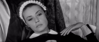 Movie still from “Diary of a Chambermaid” (1964), directed by Luis Buñuel – A black and white photo of a woman in a maid's outfit; Close Up shot, High angle