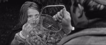 Movie still from “Diary of a Chambermaid” (1964), directed by Luis Buñuel – A woman holding a basket of food in her hands; Close Up shot, Over the shoulder angle