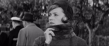 Movie still from “Diary of a Chambermaid” (1964), directed by Luis Buñuel – A black and white photo of a woman wearing a hat and a scarf; Close Up shot, Low angle