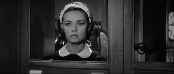 Movie still from “Diary of a Chambermaid” (1964), directed by Luis Buñuel – A black - and - white photo of a woman in a maid's outfit; Close Up shot, Low angle