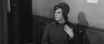 Movie still from “Diary of a Chambermaid” (1964), directed by Luis Buñuel – A young woman wearing a sweater and a hat; Medium shot, High angle