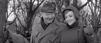Movie still from “Diary of a Chambermaid” (1964), directed by Luis Buñuel – An older man and a younger woman smiling for the camera; Close Up shot, High angle