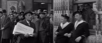Movie still from “Diary of a Chambermaid” (1964), directed by Luis Buñuel – A black and white photo of a group of men standing next to each other; Medium shot, Low angle