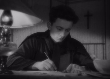 A man writing on a piece of paper with a pen