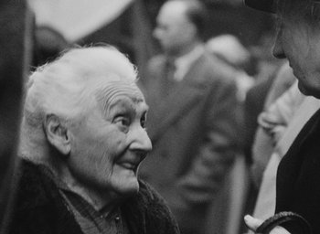 Movie still from “Diary of a Pregnant Woman” (1958), directed by Agnès Varda – An old woman is smiling while looking at the camera; Close Up shot, Over the shoulder angle