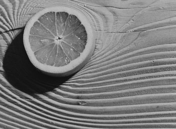 Movie still from “Diary of a Pregnant Woman” (1958), directed by Agnès Varda – A slice of grapefruit sitting on top of a wooden table; Extreme Close Up shot, Overhead angle