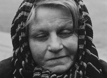 Movie still from “Diary of a Pregnant Woman” (1958), directed by Agnès Varda – An older woman wearing a scarf with her eyes closed; Close Up shot, High angle