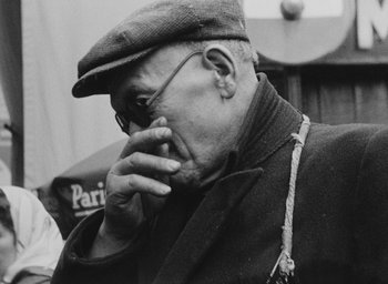 Movie still from “Diary of a Pregnant Woman” (1958), directed by Agnès Varda – An older man wearing a hat and glasses; Close Up shot, Low angle