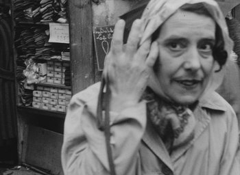 Movie still from “Diary of a Pregnant Woman” (1958), directed by Agnès Varda – An older woman holding a pair of shears in her hand; Close Up shot, Over the shoulder angle
