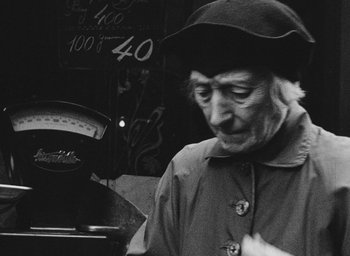 Movie still from “Diary of a Pregnant Woman” (1958), directed by Agnès Varda – An older woman wearing a hat and a jacket; Close Up shot, Over the shoulder angle