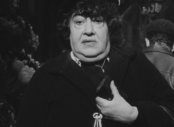 Movie still from “Diary of a Pregnant Woman” (1958), directed by Agnès Varda – An older woman holding a cell phone in her hand; Close Up shot, Low angle