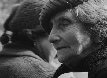 Movie still from “Diary of a Pregnant Woman” (1958), directed by Agnès Varda – An older woman wearing a hat and a scarf; Close Up shot, Over the shoulder angle