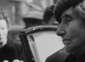 Movie still from “Diary of a Pregnant Woman” (1958), directed by Agnès Varda – An older woman is looking into the distance; Close Up shot, Over the shoulder angle