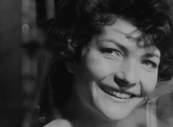Movie still from “Diary of a Pregnant Woman” (1958), directed by Agnès Varda – A black - and - white photo of a woman smiling; Extreme Close Up shot, High angle