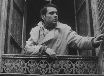Movie still from “Diary of a Pregnant Woman” (1958), directed by Agnès Varda – A black and white photo of a man looking out of a window; Close Up shot, Low angle