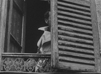 Movie still from “Diary of a Pregnant Woman” (1958), directed by Agnès Varda – An old photo of a person looking out of a window; Close Up shot, Low angle