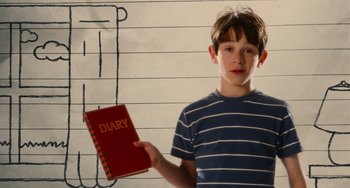 Movie still from “Diary of a Wimpy Kid” (2010), directed by Thor Freudenthal – A young boy holding a red book in his hand; Medium shot, Over the shoulder angle