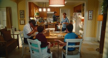 Movie still from “Diary of a Wimpy Kid” (2010), directed by Thor Freudenthal – A group of people sitting around a table in a kitchen; Wide shot, Over the shoulder angle