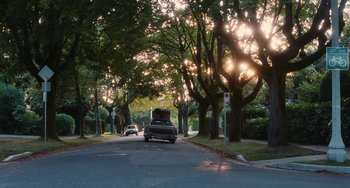 Movie still from “Diary of a Wimpy Kid” (2010), directed by Thor Freudenthal – A car driving down a street near some trees; Extreme Wide shot, Low angle