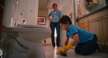 Movie still from “Diary of a Wimpy Kid” (2010), directed by Thor Freudenthal – A young boy cleaning the floor of a bathroom with a woman looking on; Medium shot, Low angle