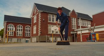 Movie still from “Diary of a Wimpy Kid” (2010), directed by Thor Freudenthal – A man sweeping the street with a broom; Wide shot, Low angle