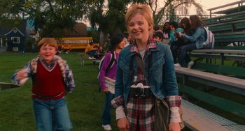 Movie still from “Diary of a Wimpy Kid” (2010), directed by Thor Freudenthal – A girl with a camera standing in front of a group of people; Medium shot, Over the shoulder angle