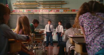 Movie still from “Diary of a Wimpy Kid” (2010), directed by Thor Freudenthal – Two young men standing in front of chalkboards in a class room; Wide shot, Low angle