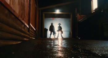 Movie still from “Diary of a Wimpy Kid” (2010), directed by Thor Freudenthal – Two people are silhouetted against a garage door at night; Wide shot, Low angle